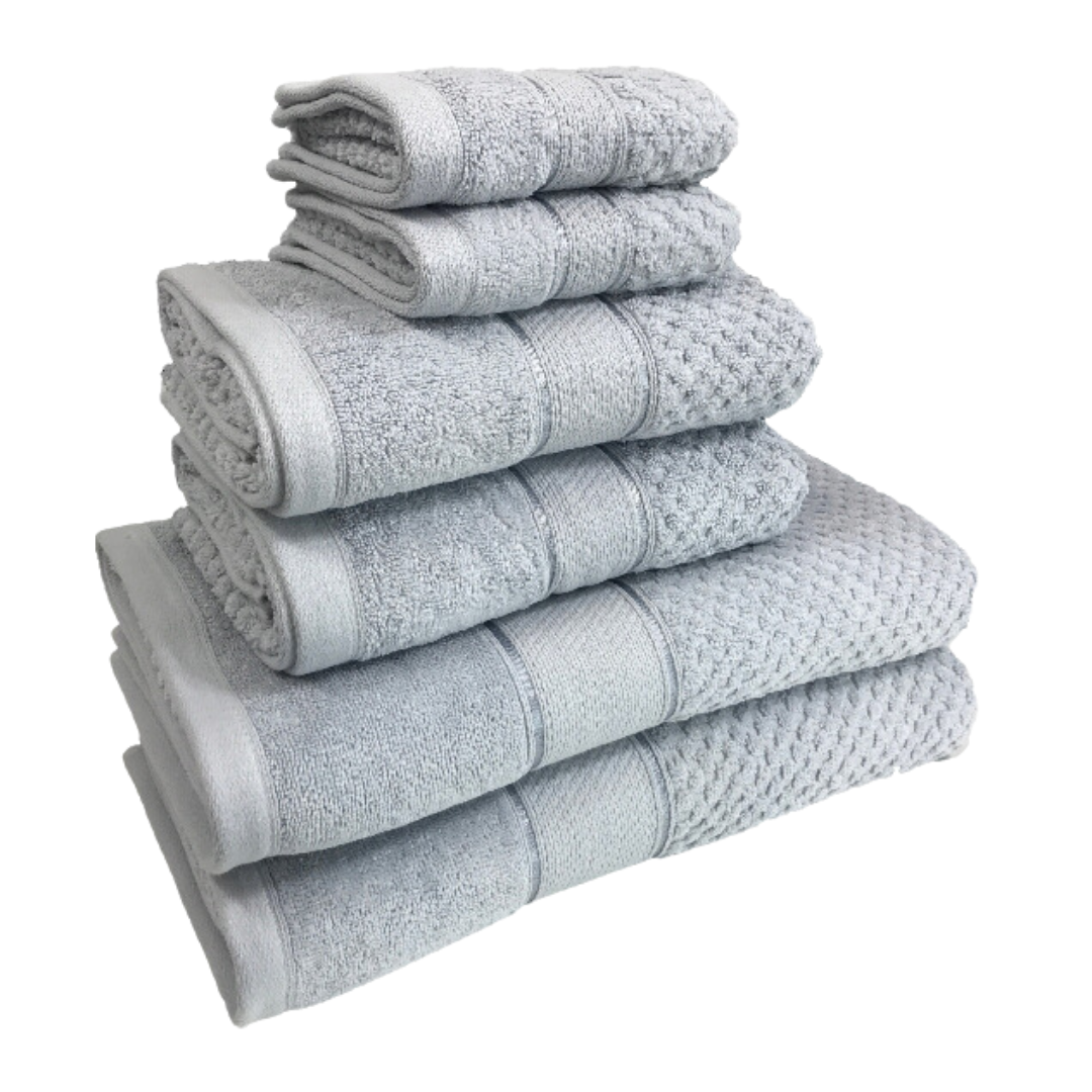 Håndklesett, seks lysegrå sammenrullede håndklær i forskjellige størrelser med strukturert mønster stablet i en haug.