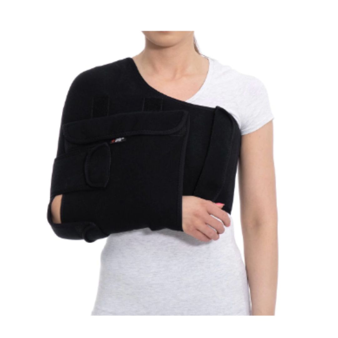 Støttebandasjer, svart støtte festet rundt en persons arm og skulder over en hvit t-skjorte.