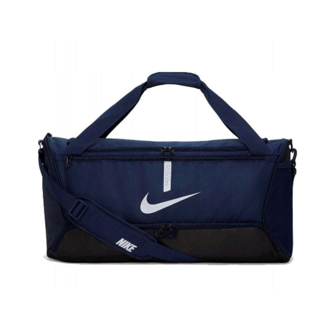 Treningsbag, mørk blå bag med svart bærehåndtak, justerbar skulderstropp og hvit logo ved glidelåsen.