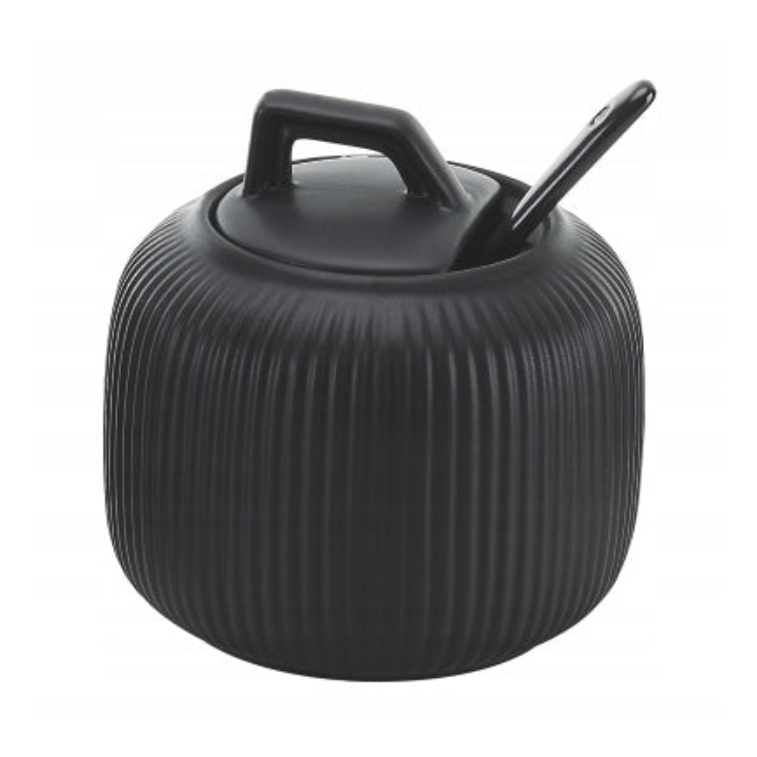 Sukkerskål, sort beholder med lokk og skje i moderne design med vertikale riller som dekorasjon.