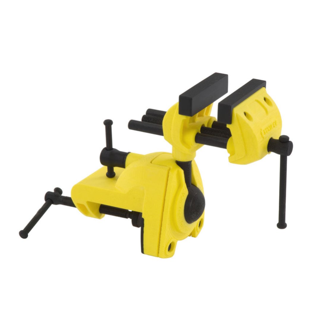 Skrustikker, gul og svart metallskrutvinge med justerbare kjever og gummibelagt håndtak i fokus.