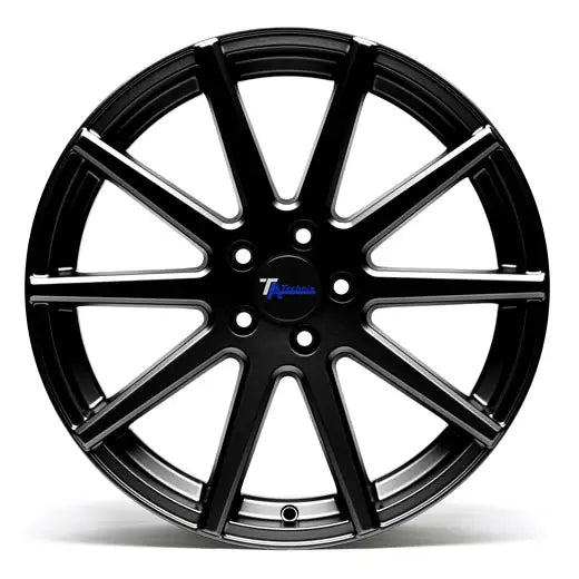 Ta Technix, svart felg med ti doble eiker, sølvfargede detaljer og blå logo i midten.