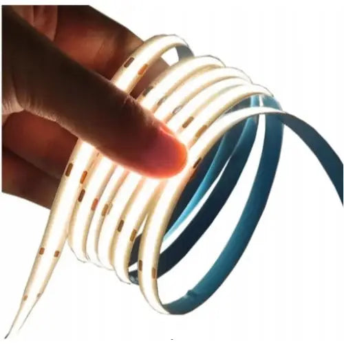 Led Strip, en hånd holder en fleksibel, hvit lysstripe med jevnt fordelte små LED-pærer som lyser.