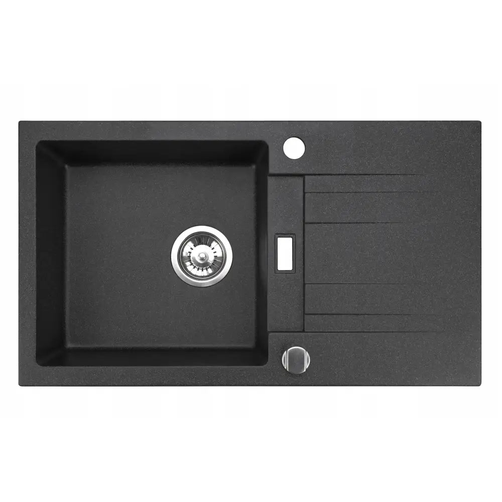 Kjøkkenvask, rektangulær svart vask med stor kum til venstre, avrenningsbrett til høyre og sølvfargede detaljer.