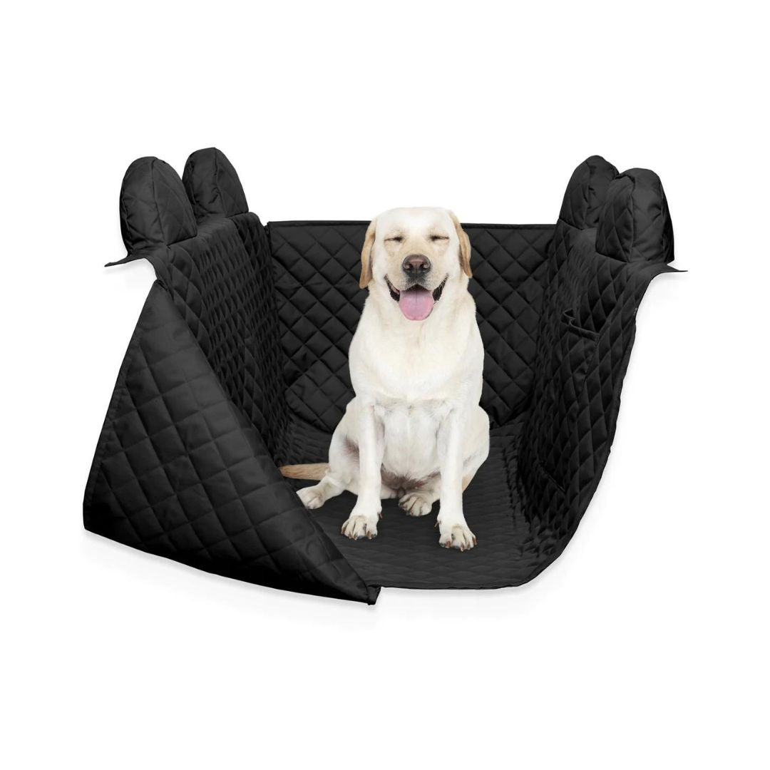 Interiør Universell, sort vattert bilsete-trekk med forhøyede kanter og en hvit hund sittende på setet.