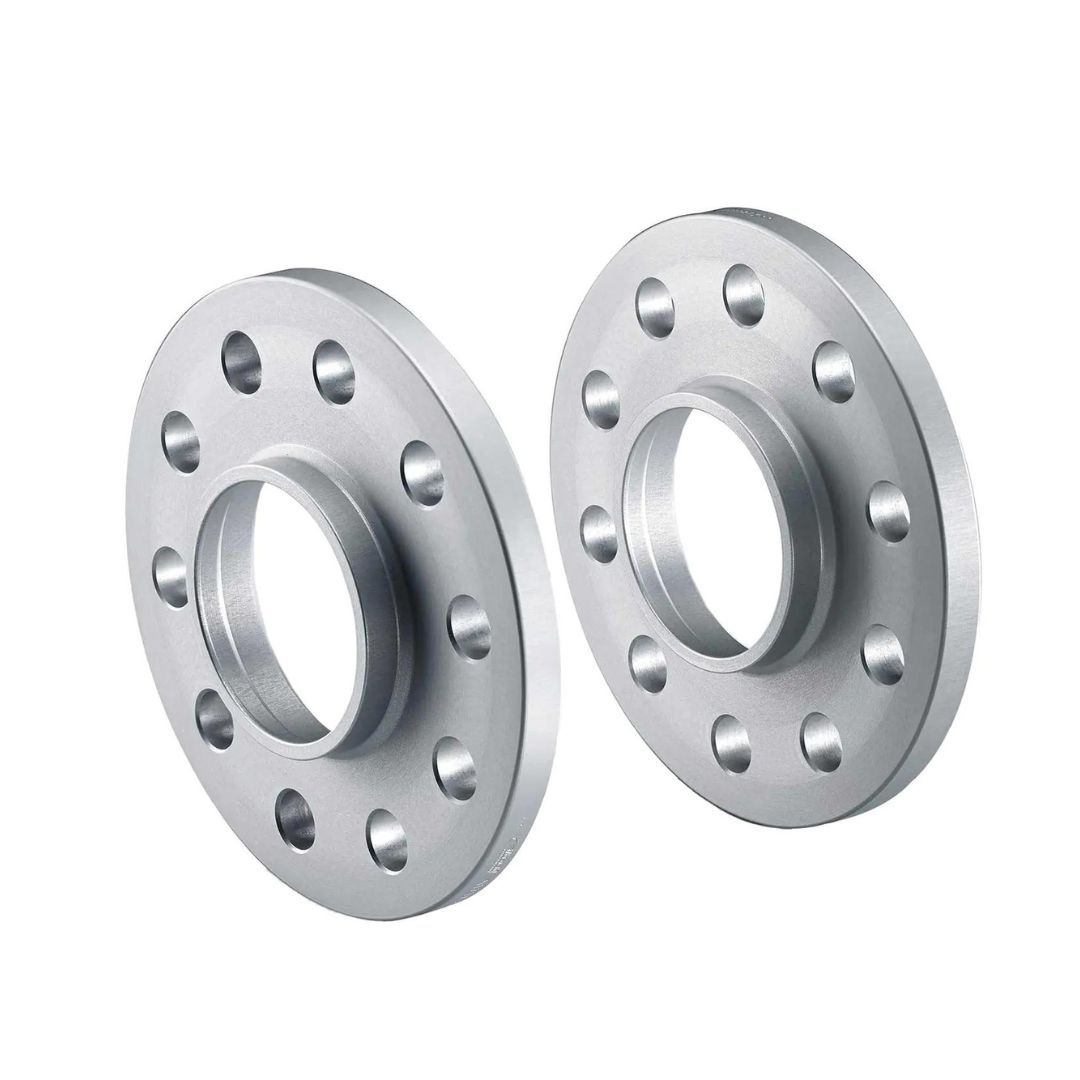 Spacere, to sølvfargede sirkulære metallskiver med flere jevnt fordelte hull og et sentrert hull.