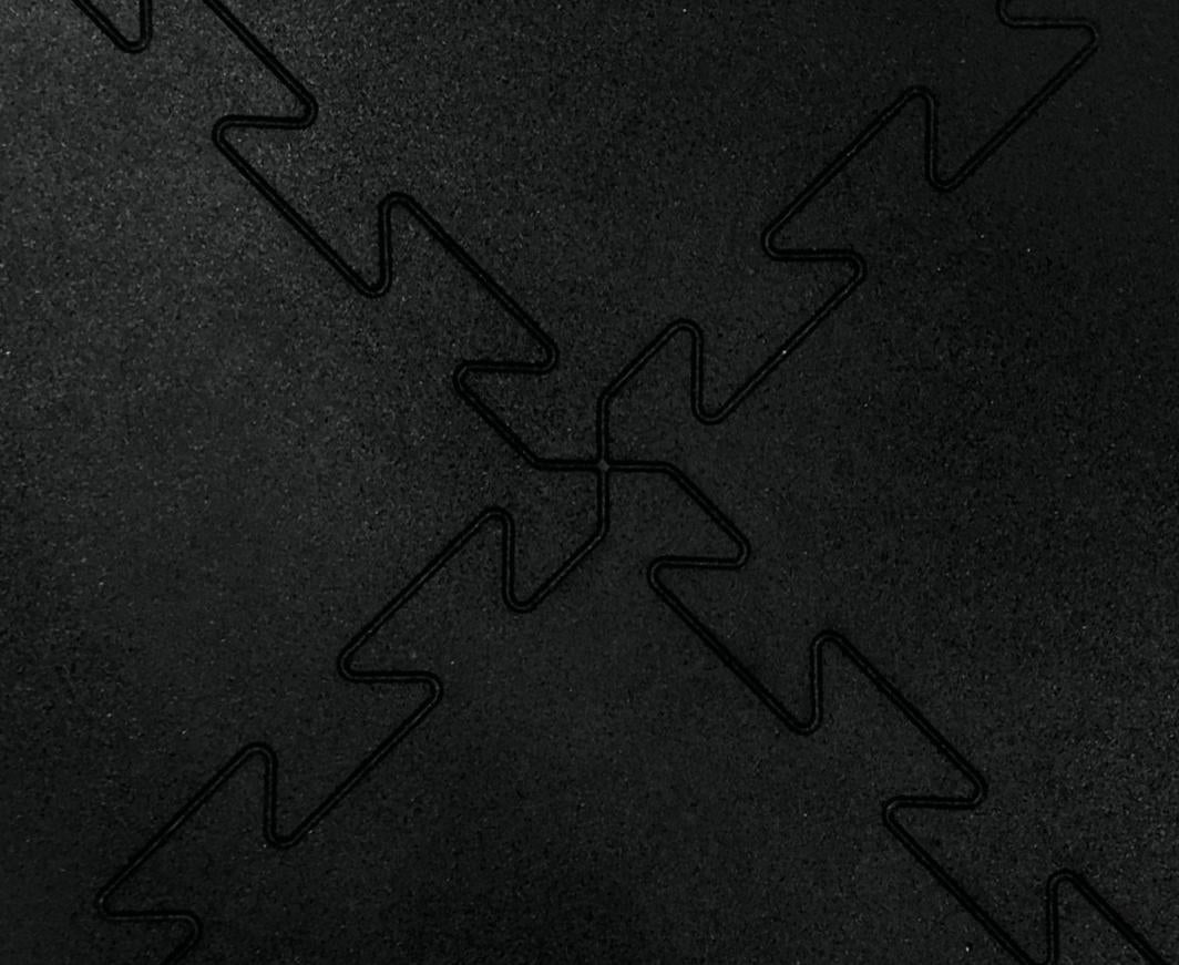 Treningsmatter Gulv med sort, matt overflate og sikk-sakk-kanter vist i detalj ovenfra med tydelig skjøtemønster.