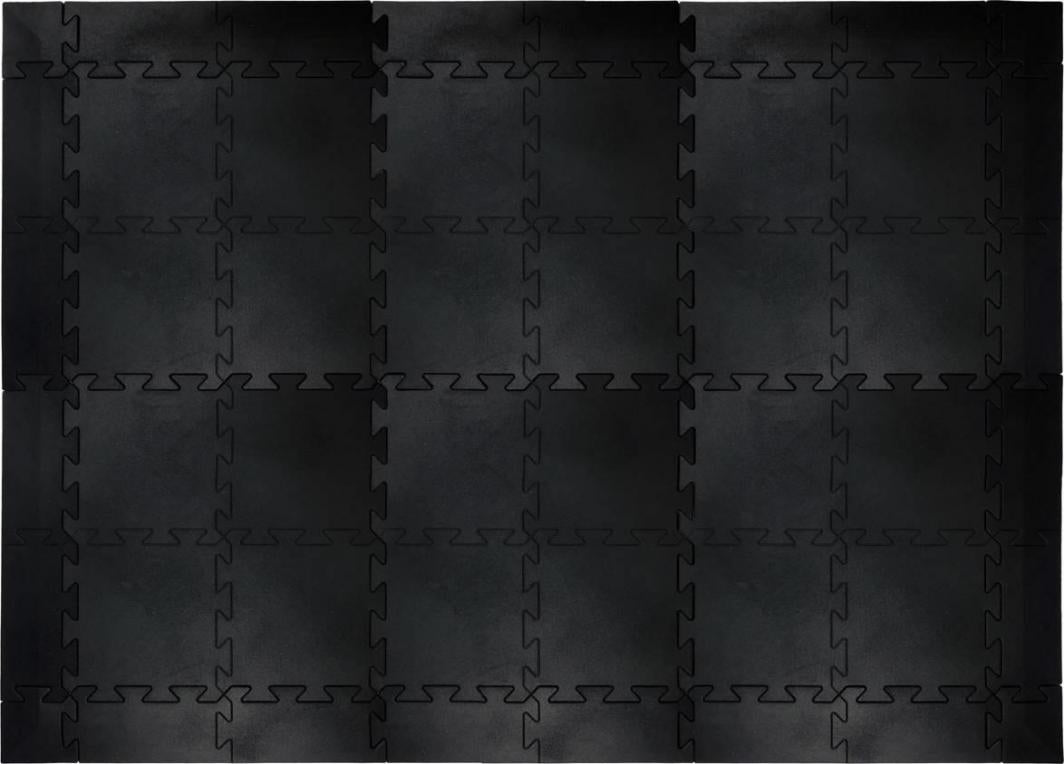 Gummigulv med sorte, firkantede moduler koblet sammen i puslespillmønster, sett ovenfra med matte kanter.