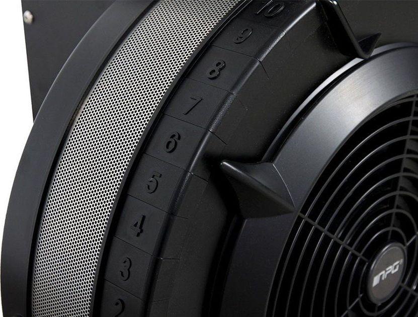 Skierg sort treningsapparat med synlig vifte, tallskala 1–10 og perforert metallgitter, vist fra siden.