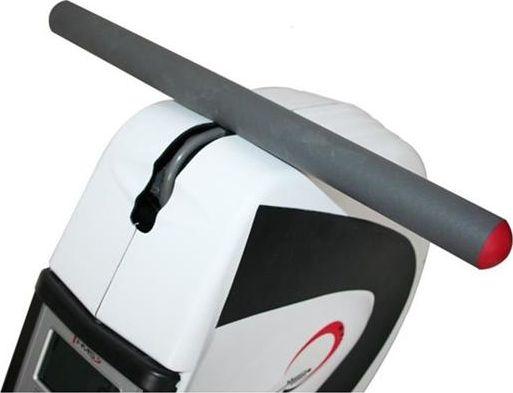 Romaskin med grå foamrulle og røde ender, plassert øverst på hvitt og svart apparat, sett fra skrå vinkel.