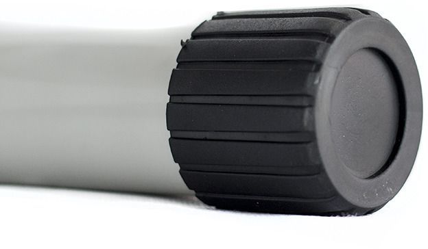 Mini Stepper grått sylinderformet endestykke med sort, riflet plastdetalj vist i nærbilde fra siden.