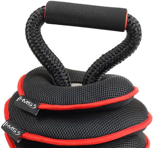 Kettlebells med svart flettet tauhåndtak, myke svarte vektskiver med rød kant, sett fra skrå vinkel.