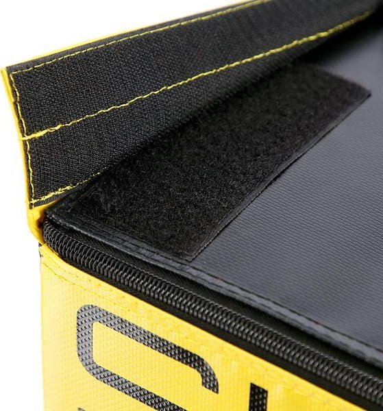 Jump Box detaljbilde av gul og svart tekstilbag med borrelåslukking, glidelås og synlige sømmer fra siden.