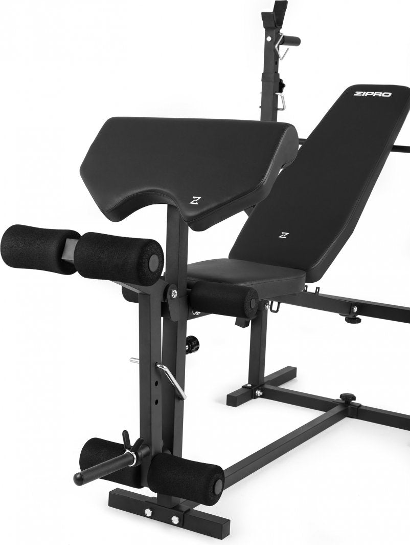 Benkpress Benk med svart polstring, metallramme, biceps curl-pult, beinrulle og justerbar ryggstøtte.