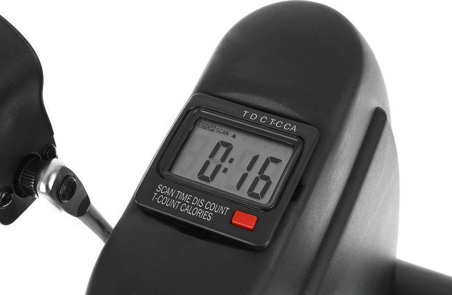 Treningssykkel med digitalt display i svart plast, rød knapp og metallarm, viser tid, teller og kalorier.