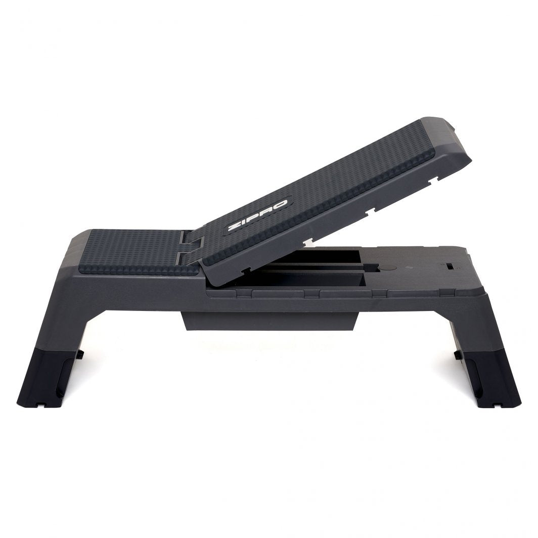 Step treningsbenk i sort plast, sett fra siden med skrå rygg, teksturert overflate og synlig Zipro-logo.