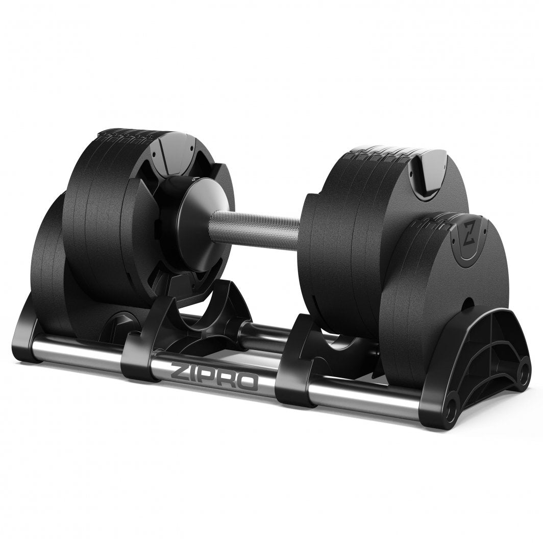 Justerbar Manual i sort og metall på stativ, sett fra skrå vinkel med håndtak og vektskiver synlige.