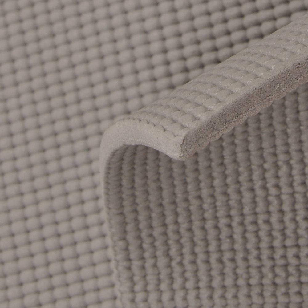 Gymmatte i grått med forhøyet tekstur, nærbilde som viser materialets tykkelse og struktur fra siden.
