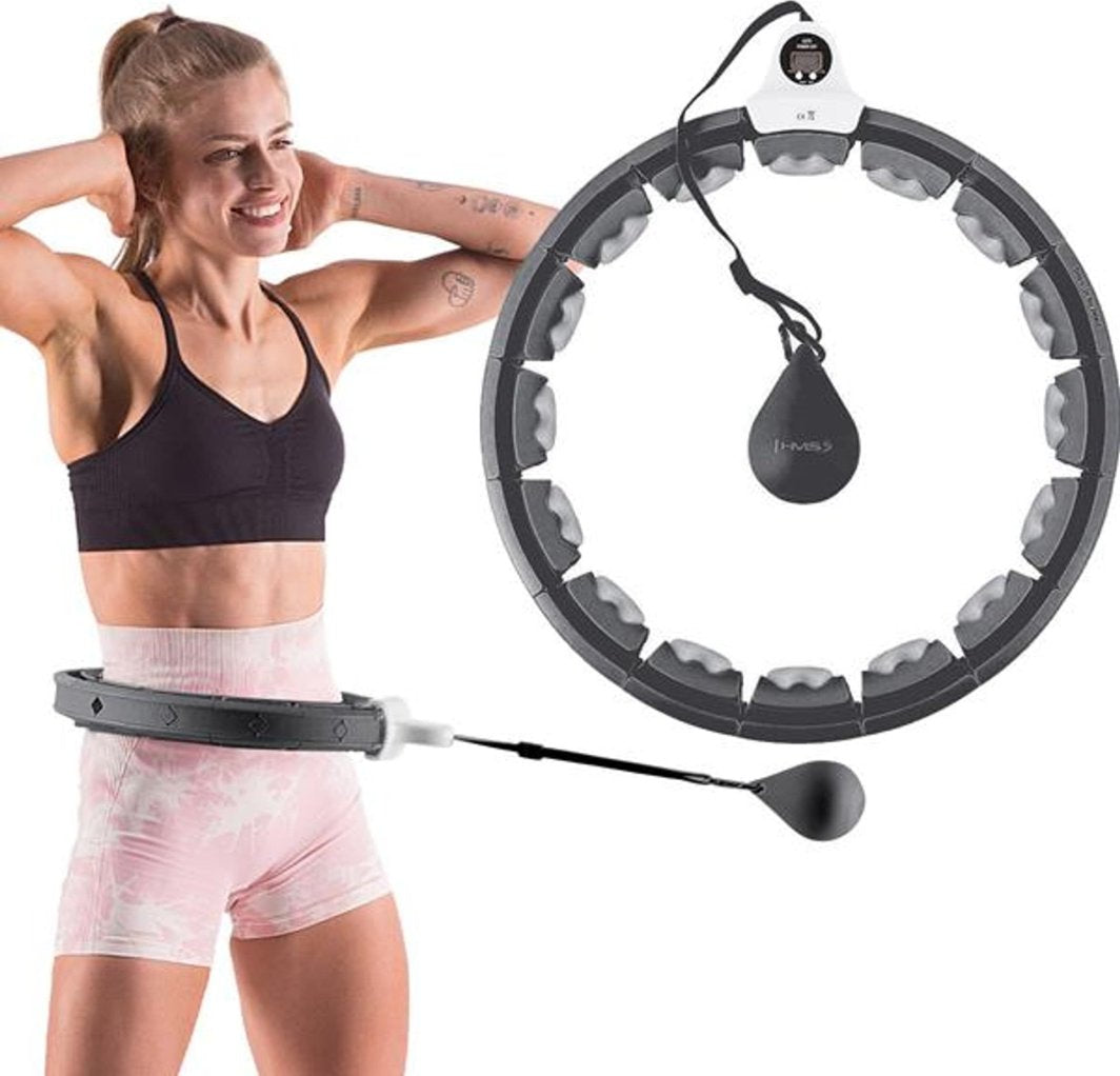 Hula Hoop treningsring i svart og grå plast, brukt rundt midjen til kvinne, med vekt festet på snor.