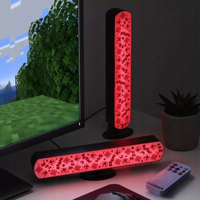 Walking Pad Lampe Minecraft RGB-lamper lyser rødt på skrivebord ved skjerm, med fjernkontroll og plante.
