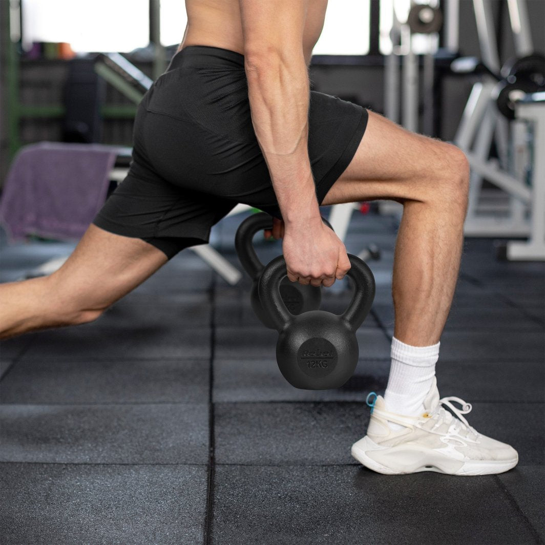 Styrketrening Hjemme, en person gjør utfall på treningssenter med sort 10 kg kettlebell fra Rebel Active.