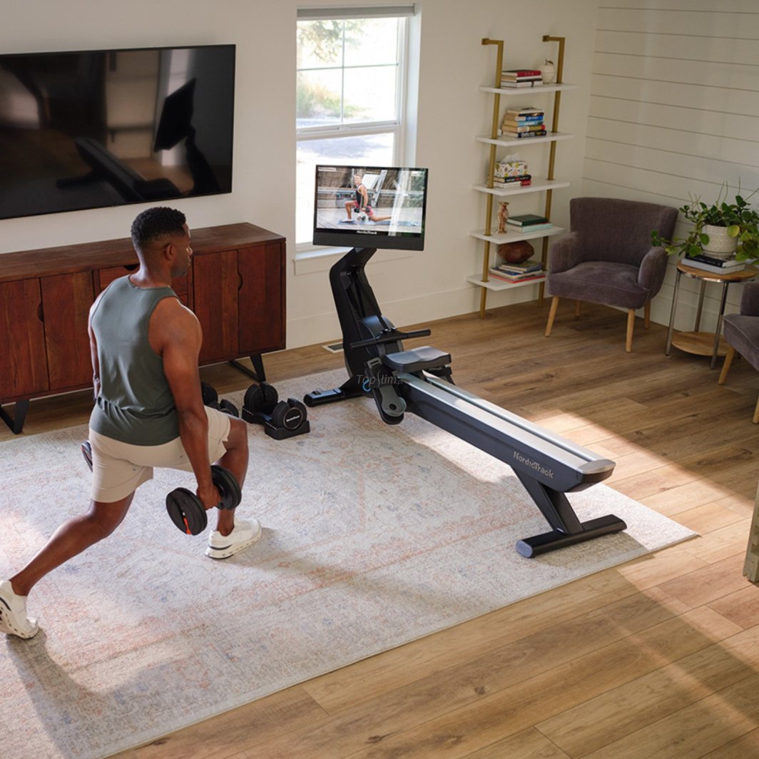 Romaskin Trening med NordicTrack RW 900 i lyst rom, person trener utfall med manualer ved siden av romaskinen.