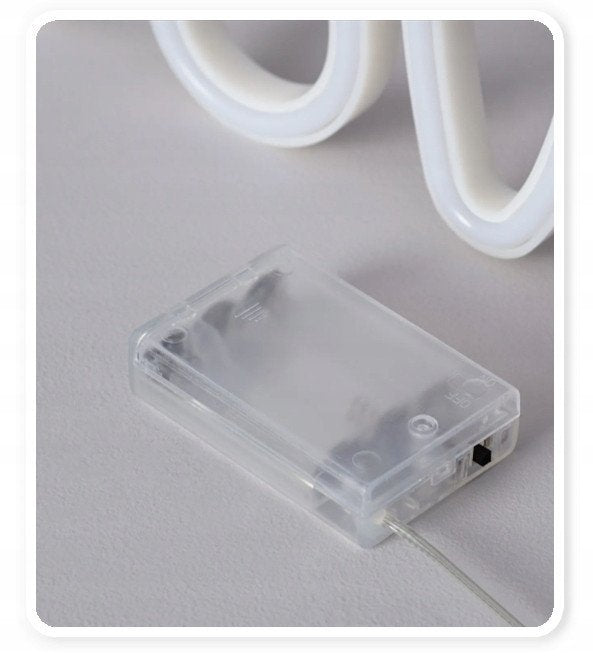 Walking Pad gjennomsiktig plastboks med ledning til neonskilt HOME, nærbilde på lys overflate.