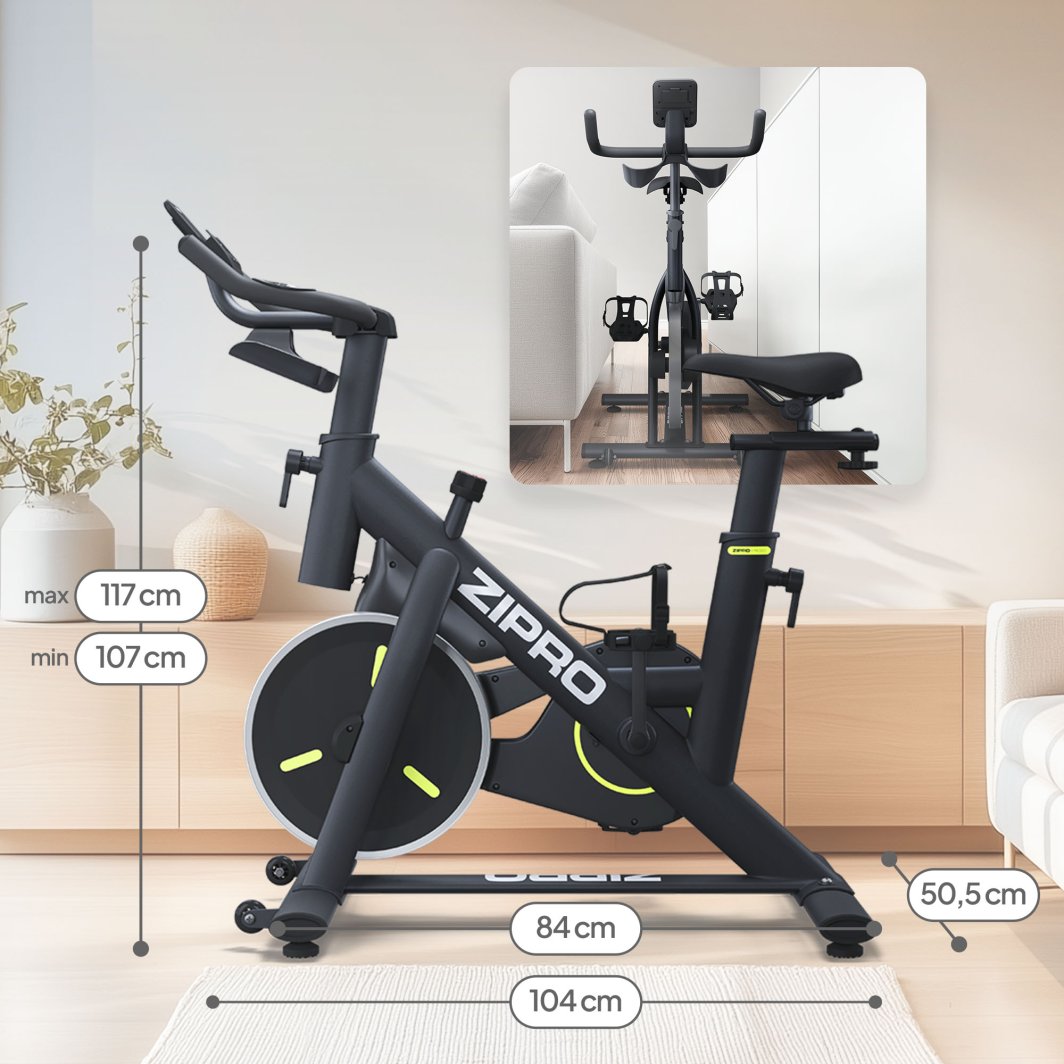 Treningssykkel i sort med grønne detaljer, sett fra siden, med mål og justerbar sadel og styre, vises forfra.