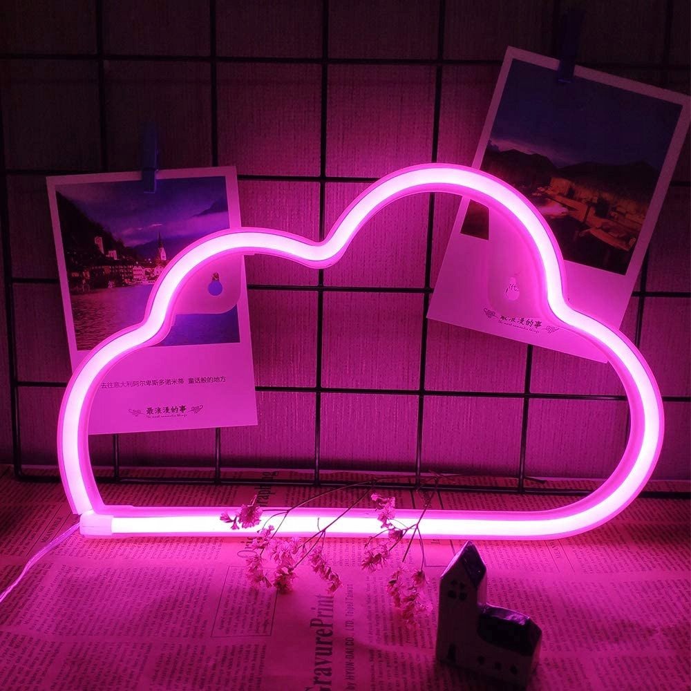 Sammenleggbar tredemølle vegglampe Sky i rosa neon, sett forfra mot nettinggitter, aviser og blomster.