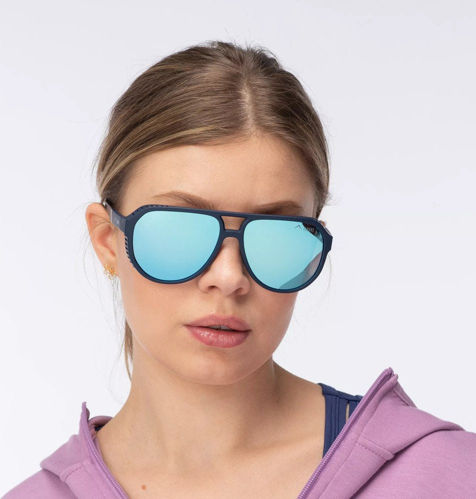 Sportsbriller med blå speilglass og mørk blå ramme, sett rett forfra på person, med tydelige sidebeskyttere.