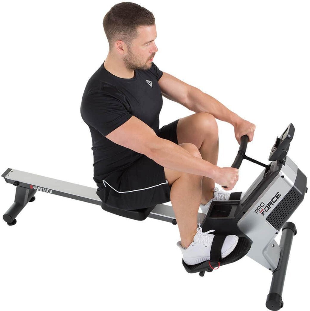 Romaskin Trening med mann i svart tøy som bruker sort og sølv romaskin med skjerm og fotstropper, sett fra siden.