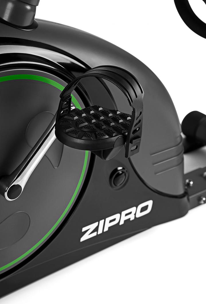 Trimsykkel med detaljbilde av pedal og pedalarm, antiskli-pedal med justerbar stropp og synlig grønn kant.