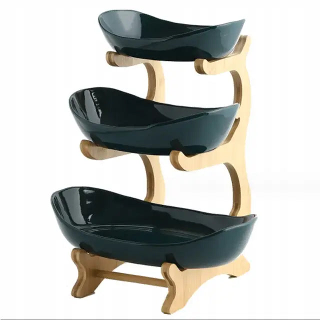3-etasjers fruktkurv med mørkegrønne keramikkfat i lyst trestativ, sidevisning mot hvit bakgrunn.