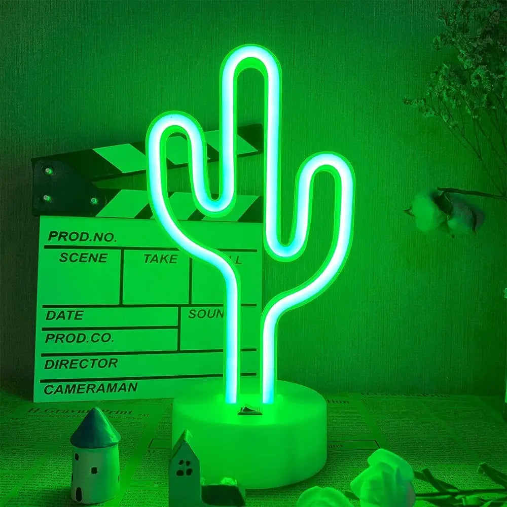 3D Neon Kaktus Lampe, grønn lysende kaktusform på hvit sokkel, fotografert forfra med dekor bak.