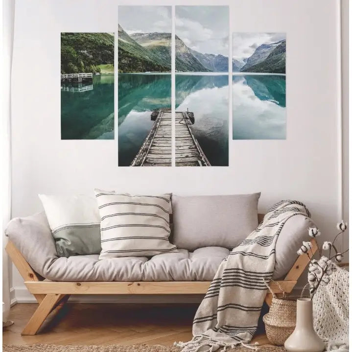 Fire veggbilder med norsk innsjø og fjell, montert over lys sofa med puter og stripet pledd i stue.