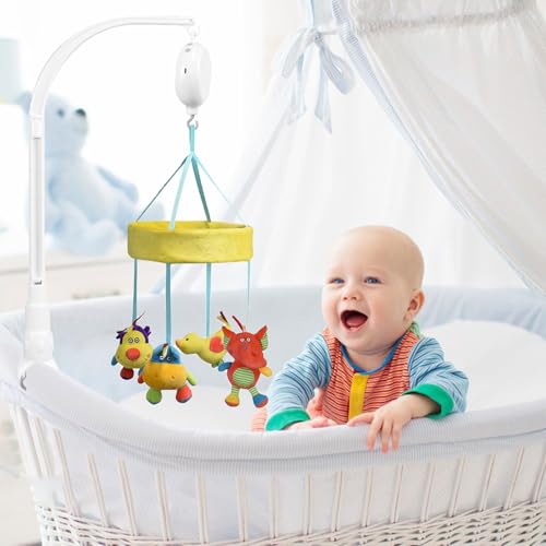 Babymobil Stativ med fargerike, myke figurer henger over hvit sprinkelseng, baby ligger under uroen.