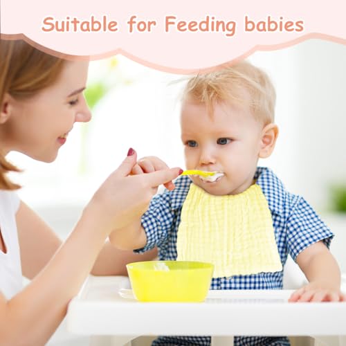 Vaskekluter Baby brukes mens en voksen mater en liten gutt i høy stol med gul smekke og gul bolle foran seg.