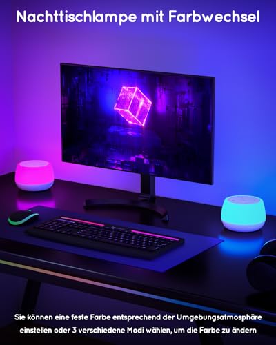 Nattbordslampe med LED-lys i rosa og blått plassert på hver side av en dataskjerm på skrivebord.