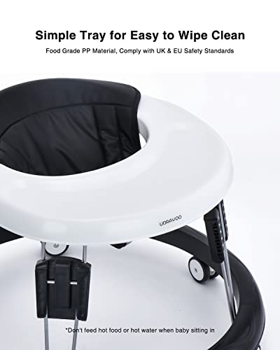 Gåstol Baby med hvitt rundt plastbrett og sort tekstilsete, sett skrått ovenfra med fokus på sete og brett.
