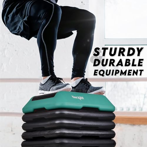Aerobics Step treningsstepkasse med sort base og grønn topp, person hopper oppå med synlige ben og sko.