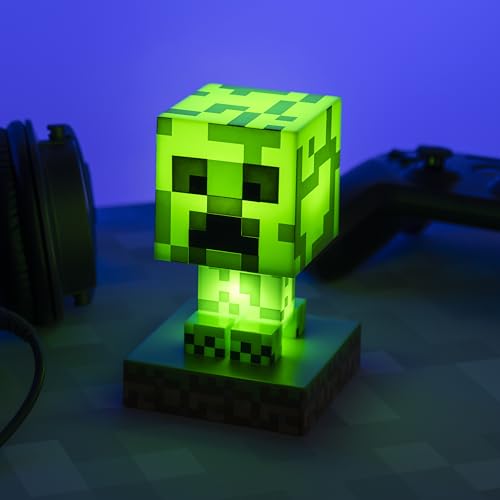 Lamper formet som grønn Minecraft Creeper-figur med LED-lys, står tent på bord med firkantede mønstre.