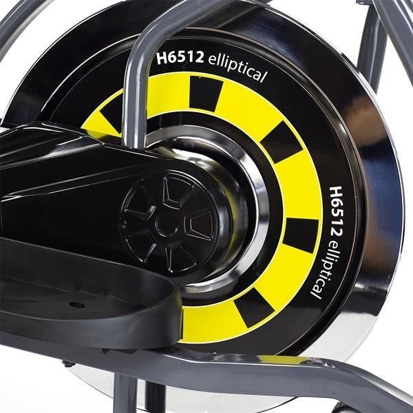 Ellipsemaskin med svart og gult svinghjul, sølvdetaljer og teksten "H6512 elliptical" sett fra siden.
