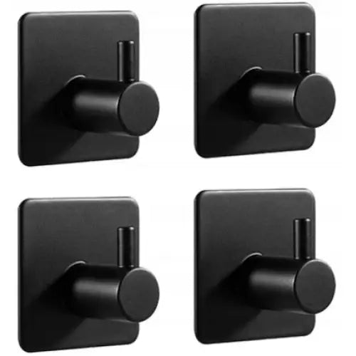 Selvklebende baderomskroker i matt svart metall, fire stykker på kvadratiske plater sett fra skrå vinkel.
