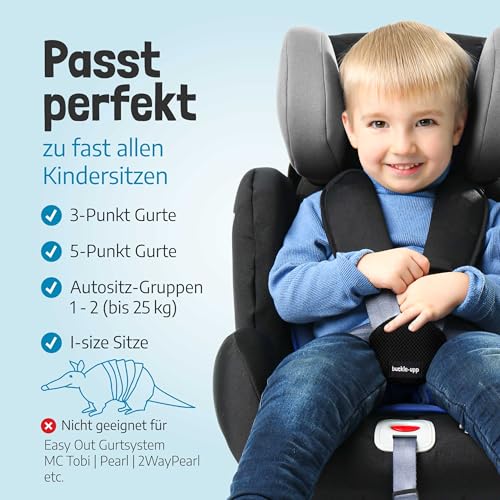 Barnesete med smilende barn i svart bilbarnestol og grå polstring, festet trygt med sele, sett forfra.
