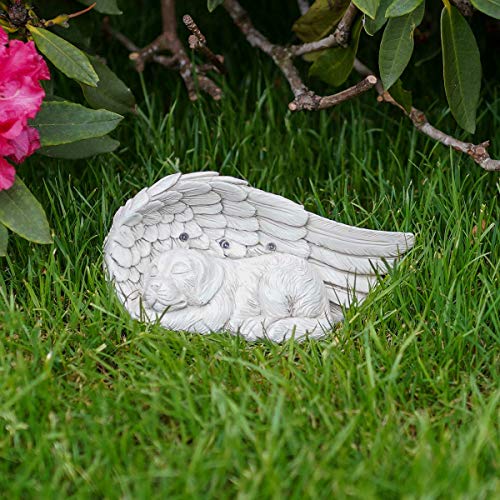 Gravpynt dekorativ skulptur av sovende hund med stor englevinge i grå steineffekt, plassert på grønt gress.