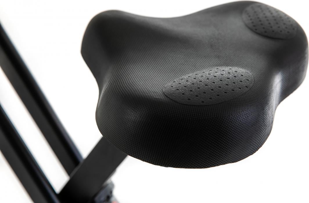 Trimsykkel med sort, ergonomisk sete i plast, to gripefelt med små hull for økt komfort, sett fra skrå vinkel.