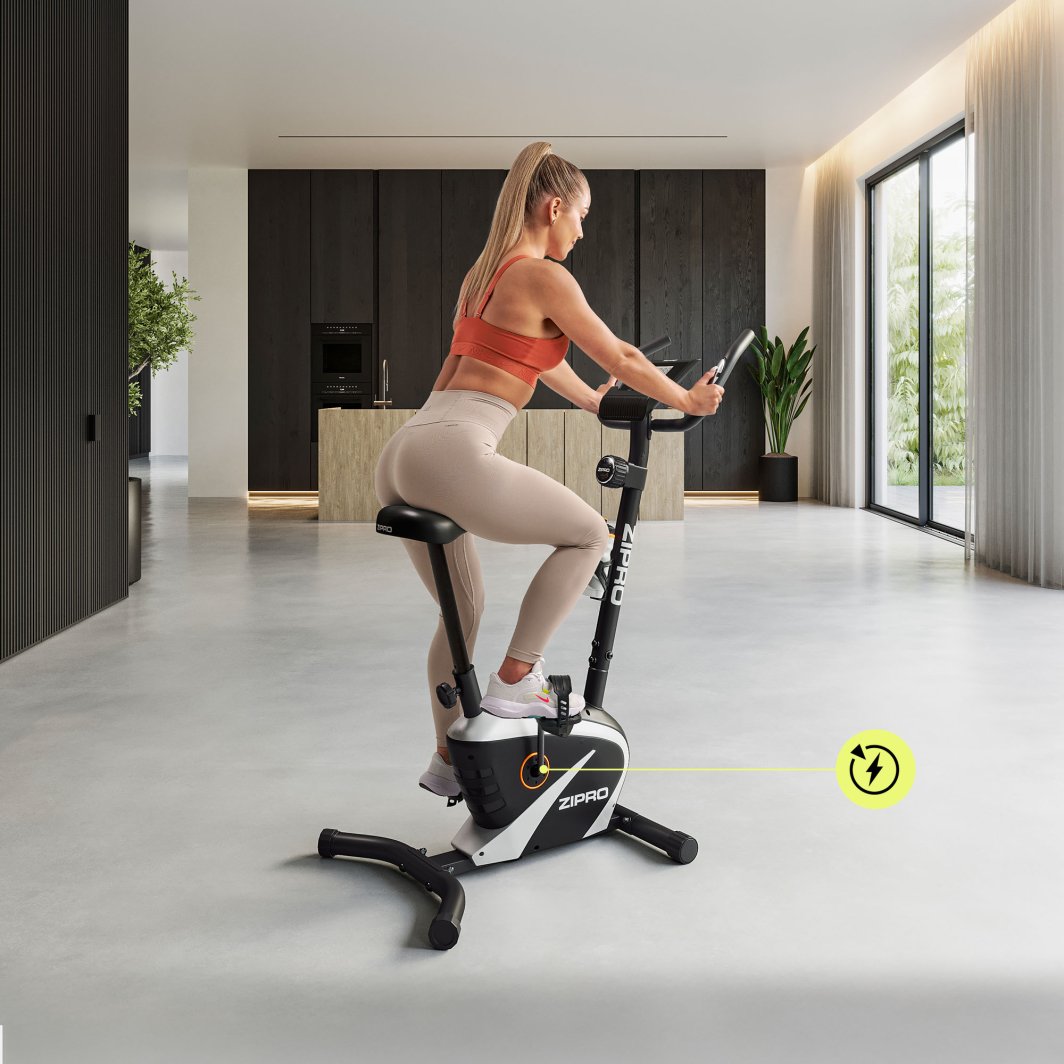 Ergometersykkel i sort og hvitt med tydelig display, kvinne trener på sykkelen i lyst rom med store vinduer.