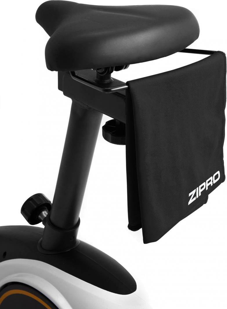 Treningssykkel sete i svart plast sett fra siden, med håndkle med ZIPRO-logo hengende på stang bak setet.