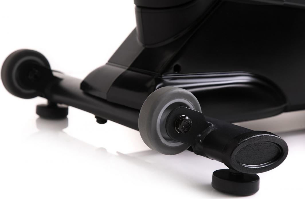 Crosstrainer med sort metallramme, grå hjul og justerbare føtter, vist i nærbilde fra siden.