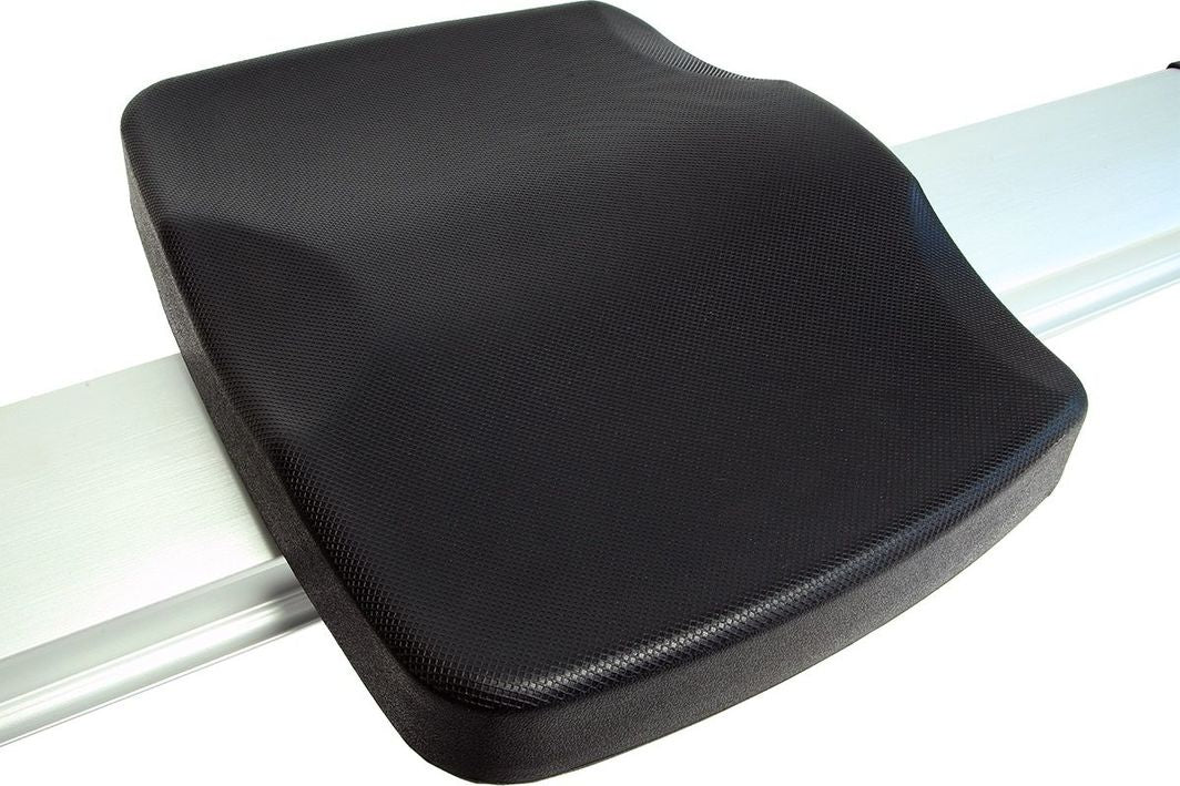 Romaskin med sort, strukturert plastsete montert på metallskinne, sett skrått ovenfra.